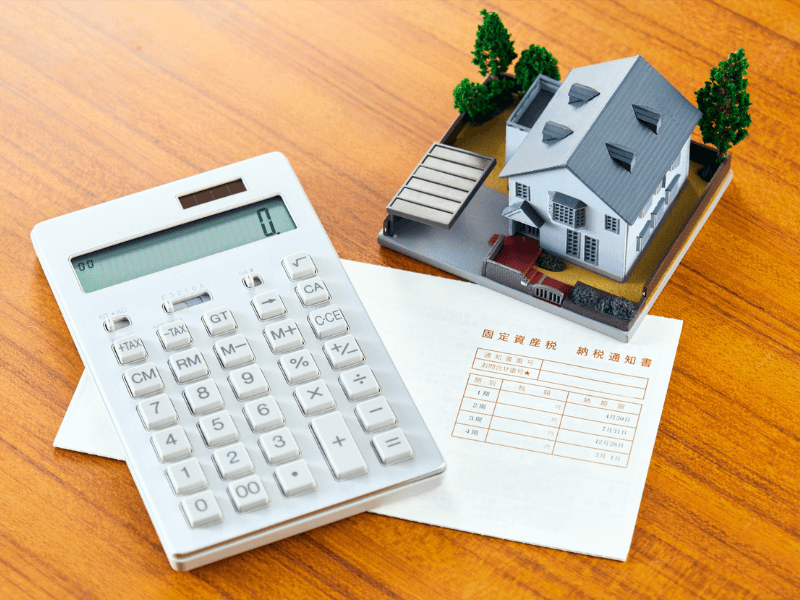 un-escritorio-con-una-calculadora-una-maqueta-de-una-casa-haciendo-un-presupuesto-de-construccion-paso-a-paso